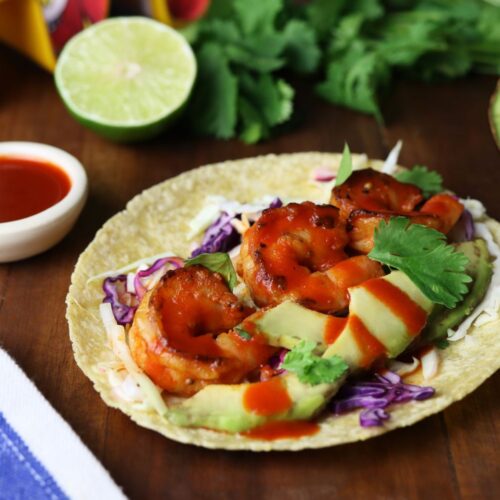 honey sriracha shrimp tacos on a table with ingredients