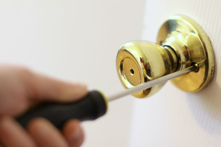 Taking Off Old Door Handle With a Screwdriver