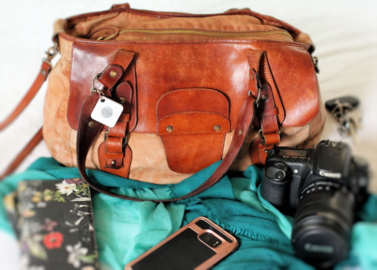 Tile Tracker sur un sac avec un appareil photo et un téléphone