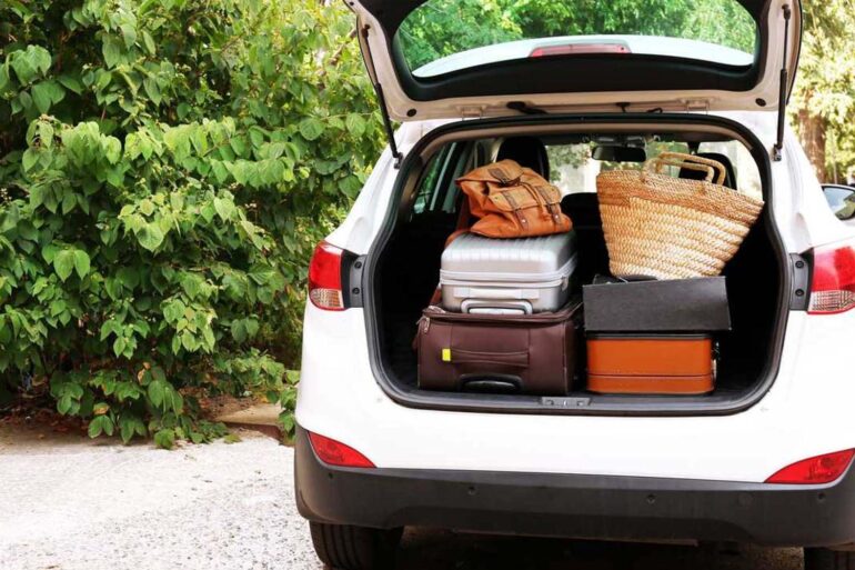an suv from the rear, back hatch open filled with luggage on a summer day.