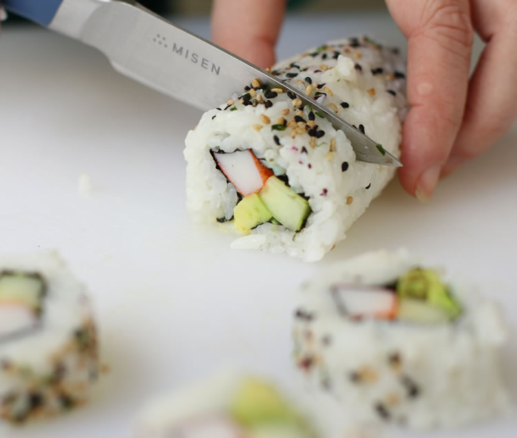 cutting a California roll with a knife