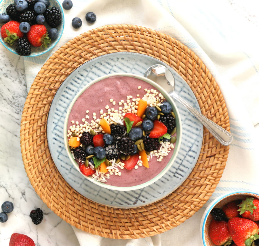 Mixed Berry and collagen peptide smoothie bowl topped with strawberries, blackberries, apricots, shredded coconut and pumpkin seeds.