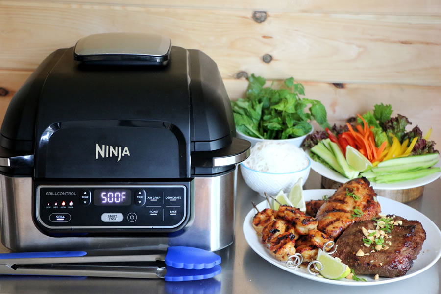 The Ninja Foodi Grill on a counter next to a Vietnemese Mixed Grill Platter