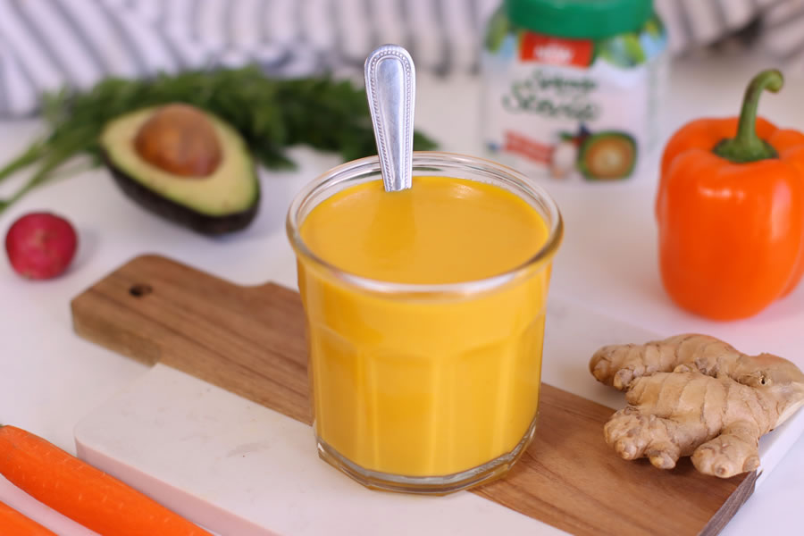 Low-Carb Carrot-Ginger Dressing in a glass jar on a cutting board
