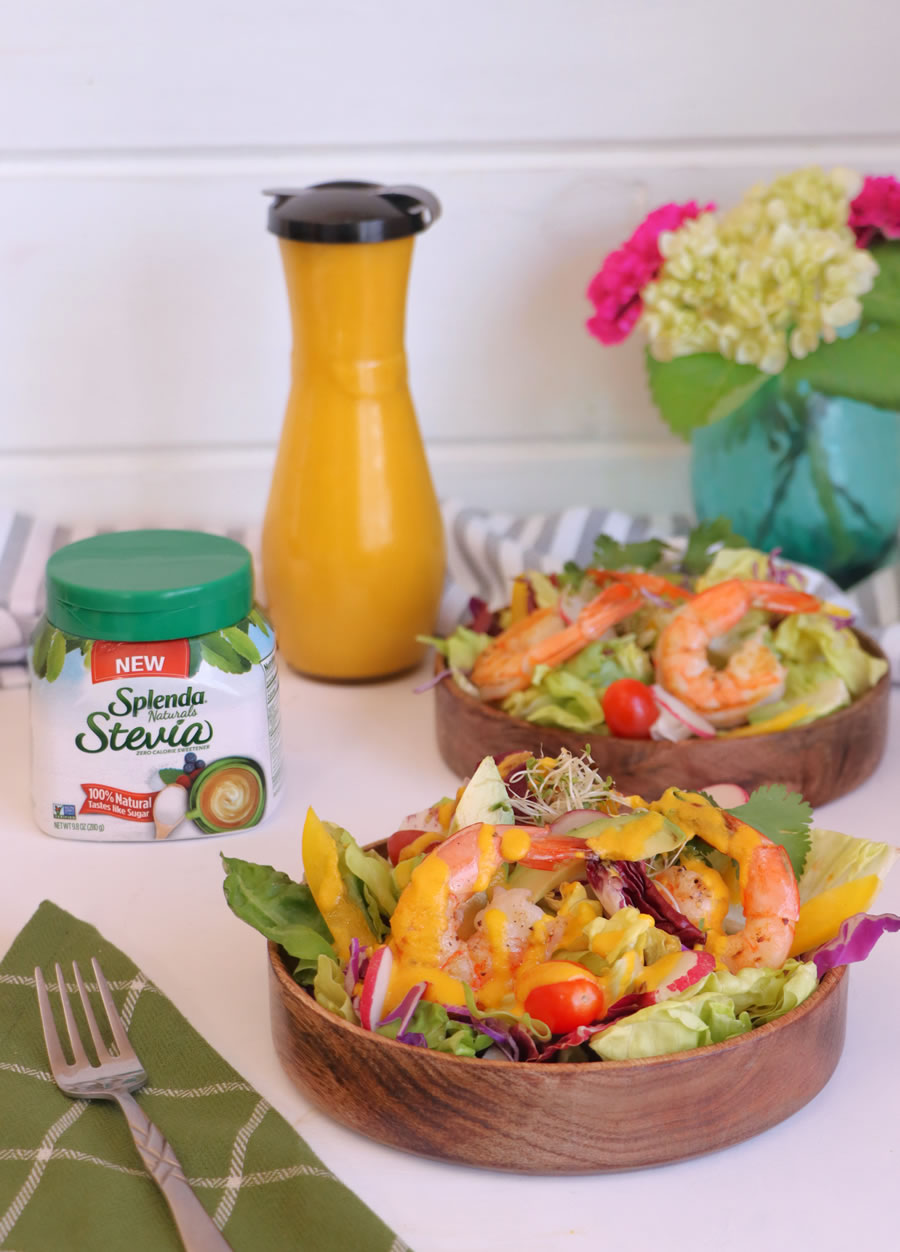 Low-Carb Carrot-Ginger Dressing over two salads with flowers and dressing in the back