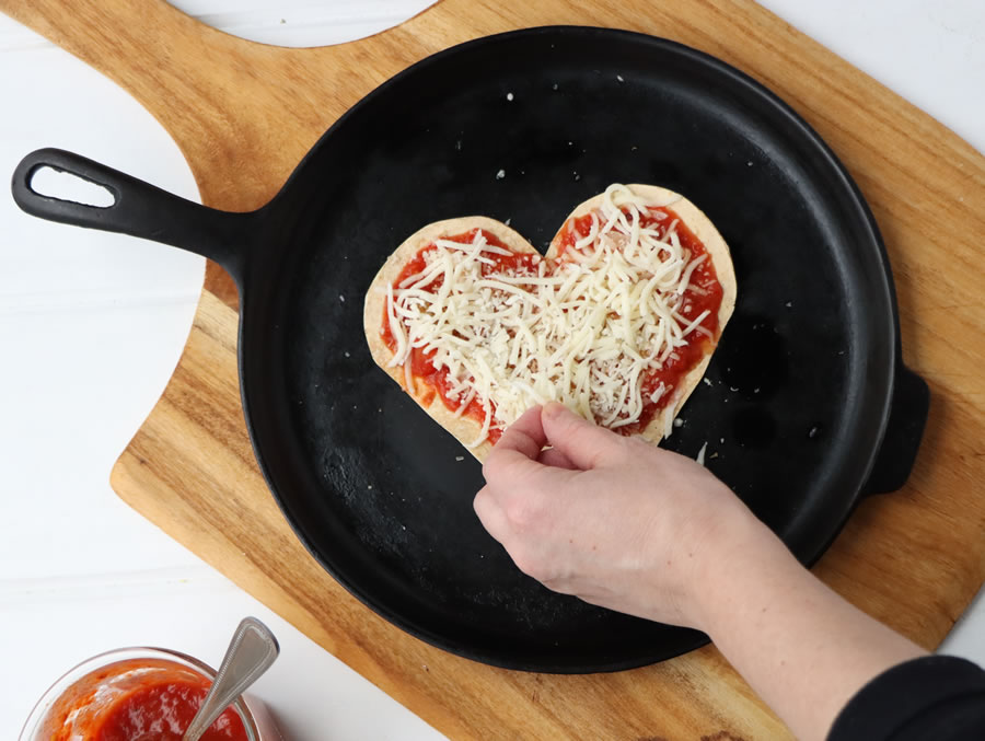 Skillet tortilla pizza topped with shredded mozzarella cheese