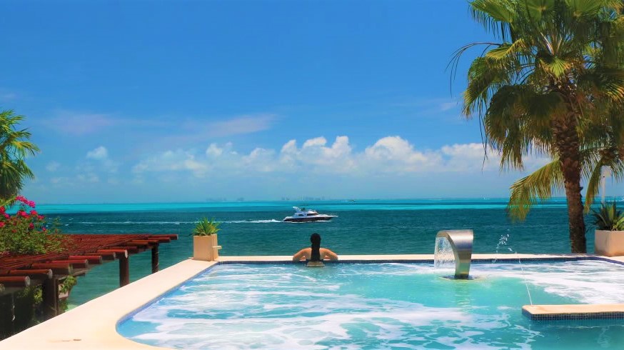 Girl overlooking blue ocean in jacuzzi living best life