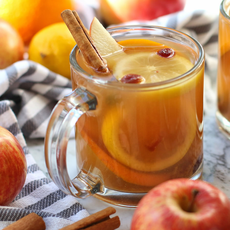 clear mug of hot spiced mulled apple cider fall beverage stevia cinnamon sticks