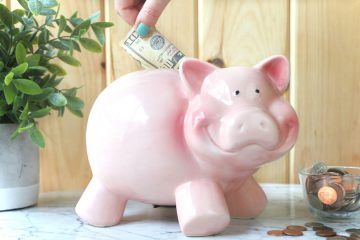 putting money in a pink piggy bank https://www.onbetterliving.com