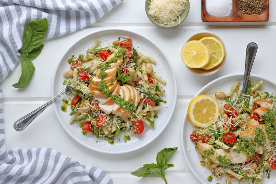 Two Plates of Chicken Basil Pesto Pasta served with lemon