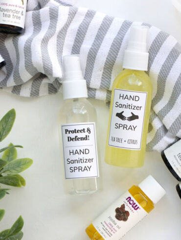 DIY Hand Sanitizers displayed next to essential oils of orange tea tree lemon and peppermint