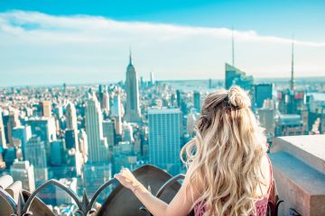 a blonde woman looking out over New York City