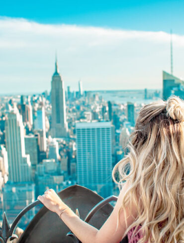 a blonde woman looking out over New York City