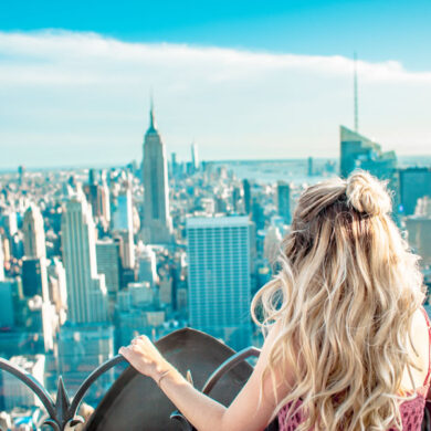 a blonde woman looking out over New York City