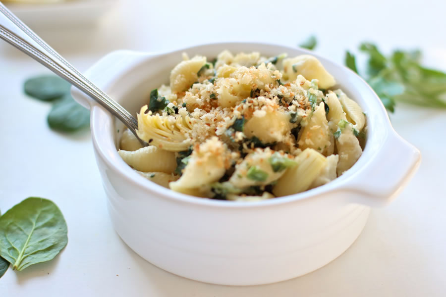 bowl of mac and cheese with spinach and artichoke