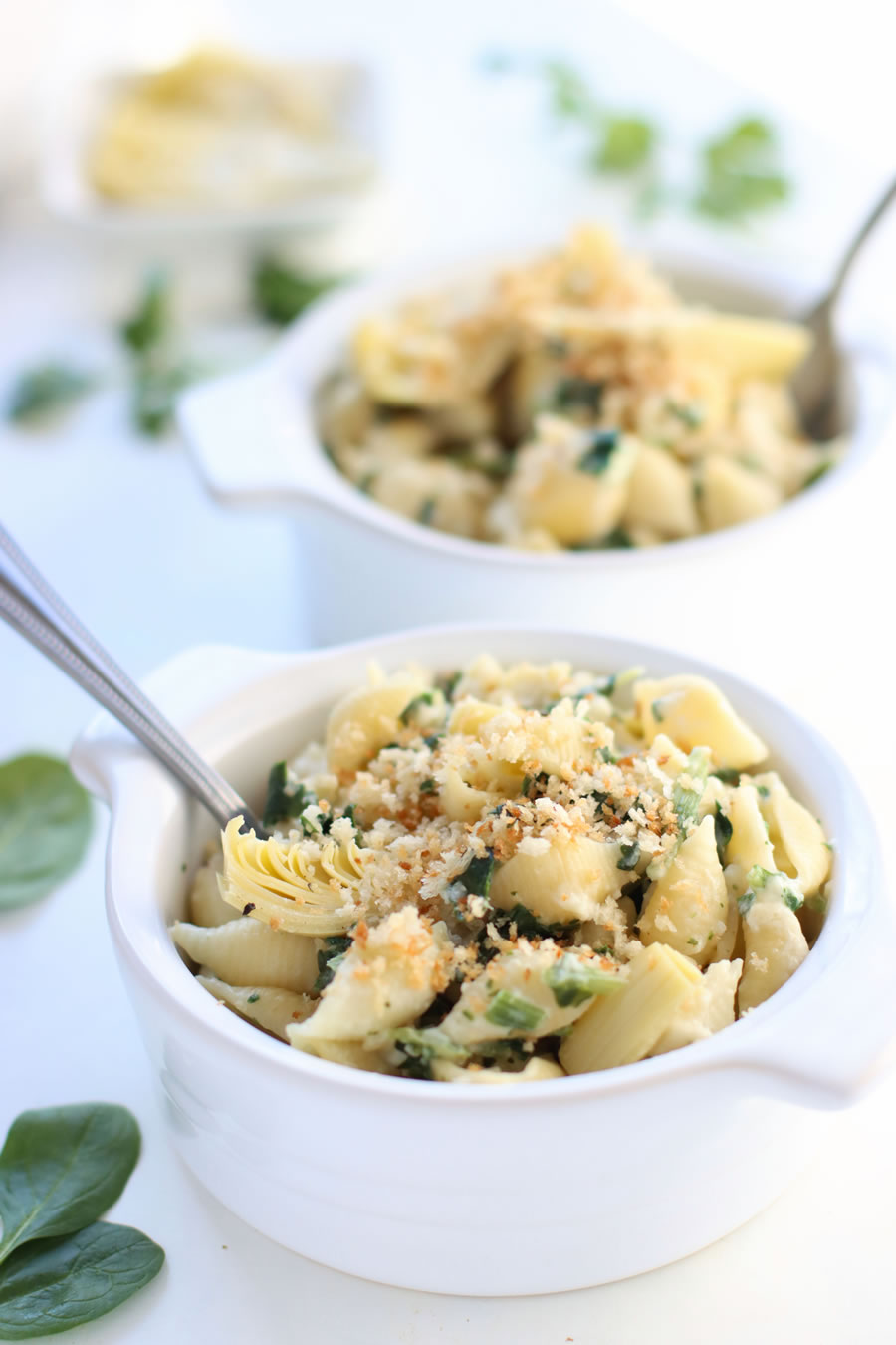 two bowls of spinach and artichoke mac and cheese