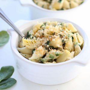 Spinach & Artichoke Greek Yogurt Mac Cheese in a white bowl with a spoon