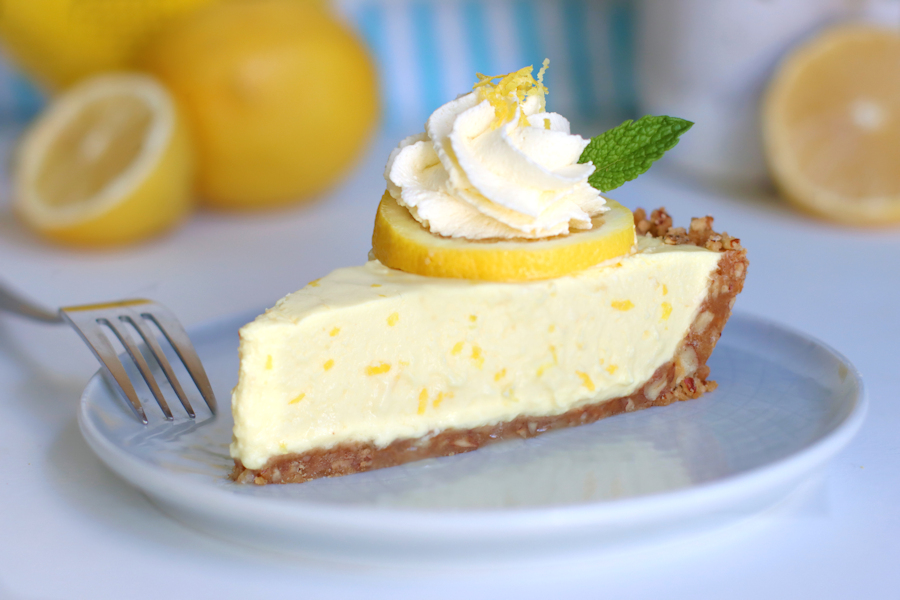 A slice of Greek Yogurt Lemon Cream Pie decorated with lemon zest and whipped cream | onbetterliving.com