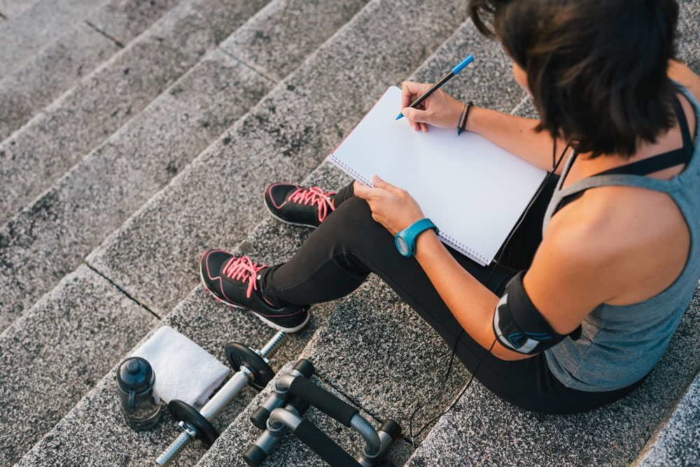 A woman writes in her fitness journal