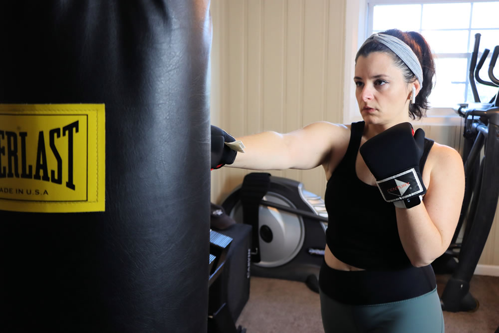 A woman boxing a heavy bag for fat loss and cardio health