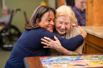 People hugging at a memory care facility