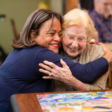 People hugging at a memory care facility
