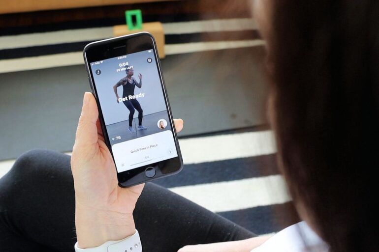 A woman using the Future Fitness app on her phone.