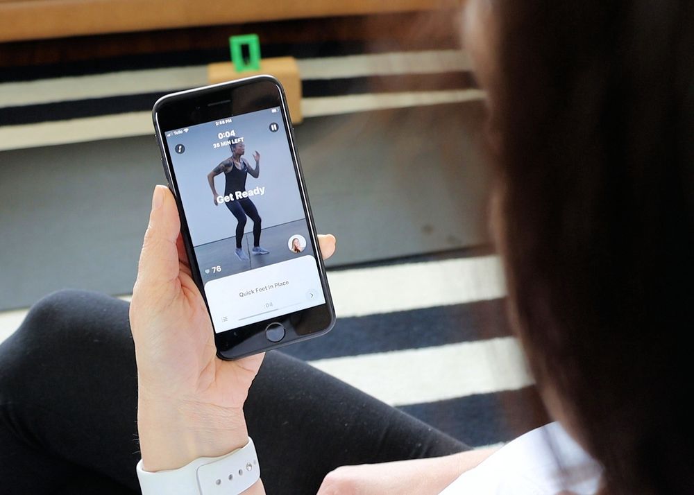 A woman using the Future Fitness app on her phone.