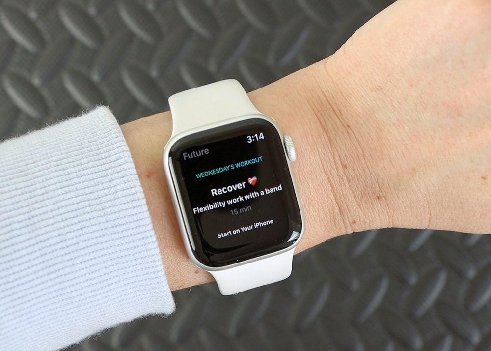 A woman checks her Apple Watch for the recovery phase of her Future workout.