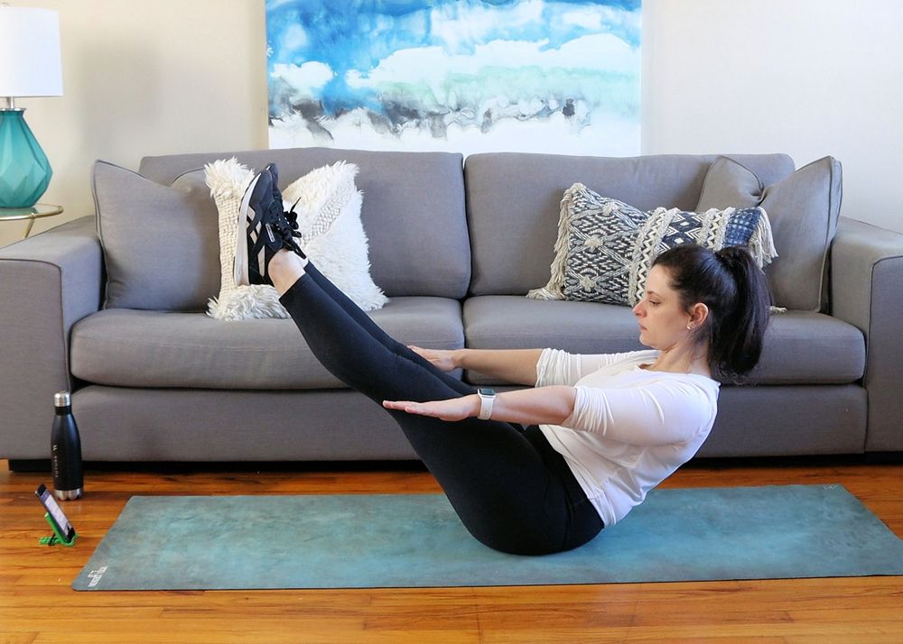 A woman doing yoga at home with a fitness app