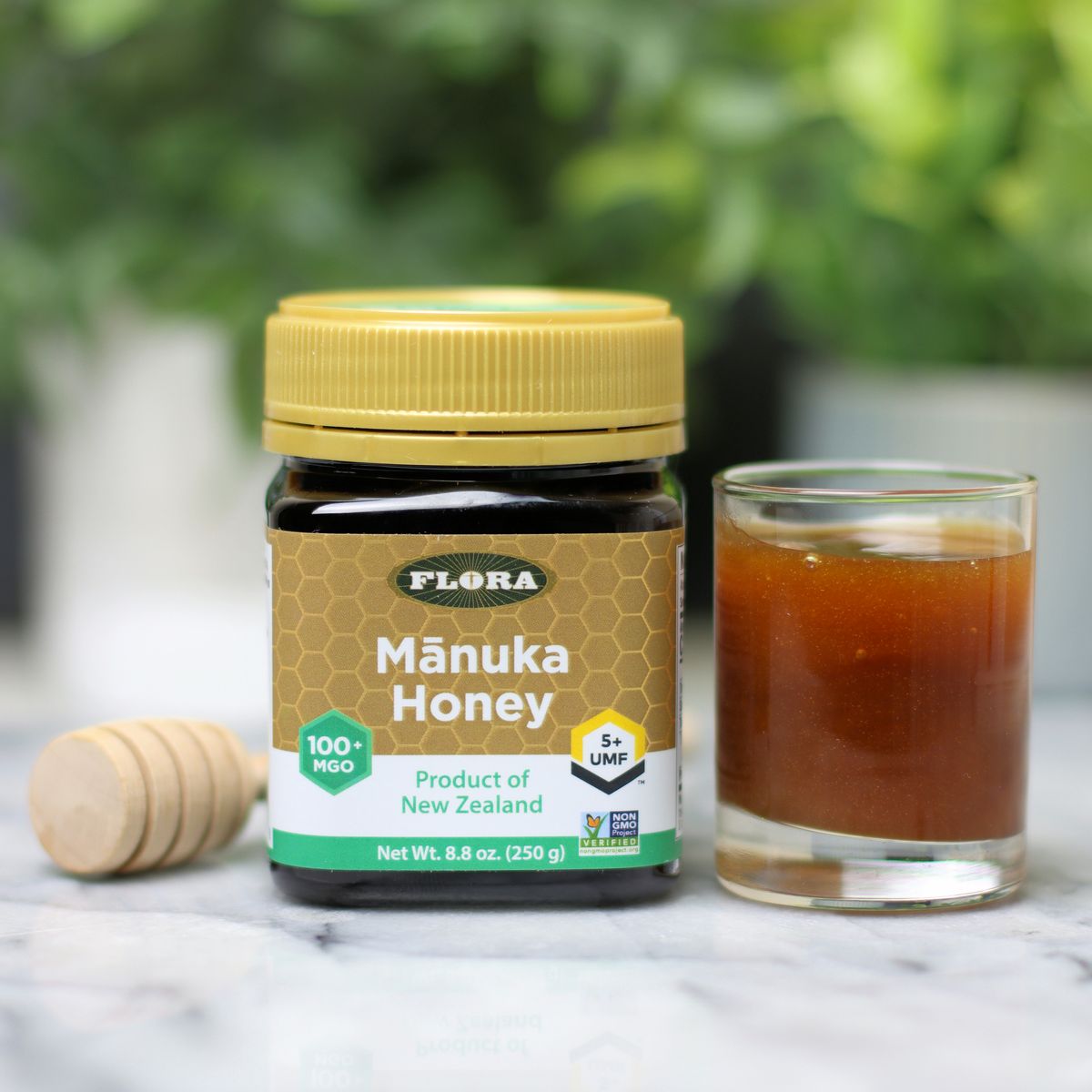 A jar of Flora Manuka Honey next to a serving in a glass jar