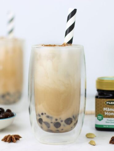 Two healthy, iced chai boba teas and a jar of Flora Manuka Honey