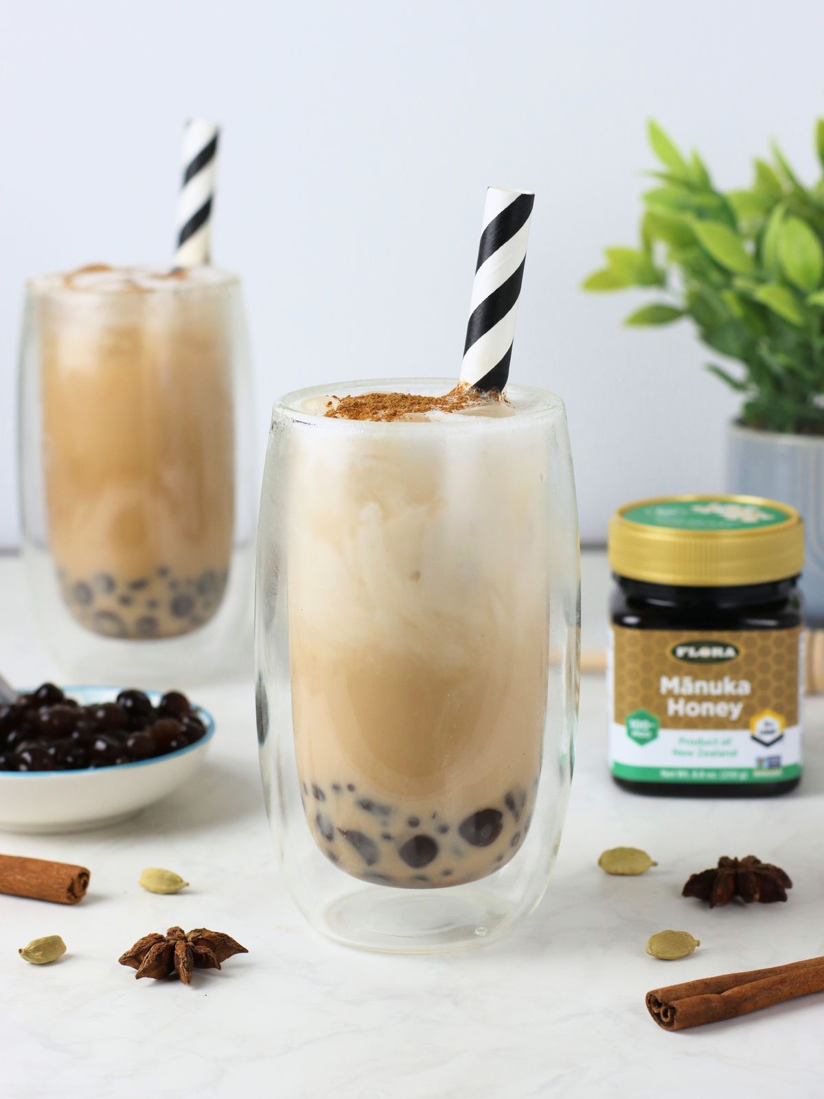 Two glasses of healthy iced chai bubble tea with Flora Manuka honey
