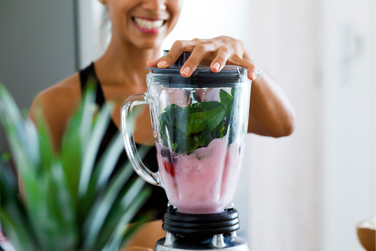 A woman makes a healthy smoothie