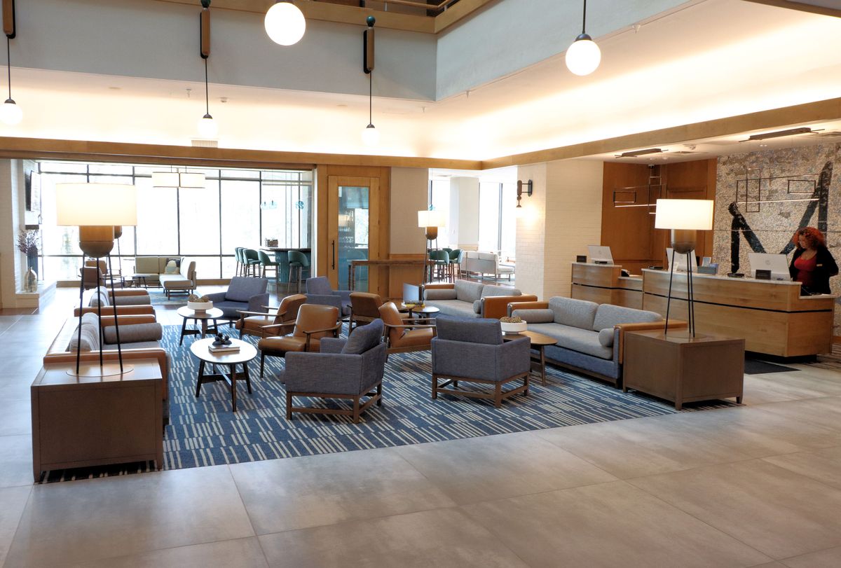 The lobby at Merriweather Lakehouse Hotel with a check in desk, multiple couches and chairs. 