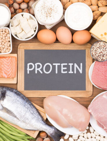 A selection of lean protein sources on a table including fish, chicken, eggs, tofu, legumes, and more.