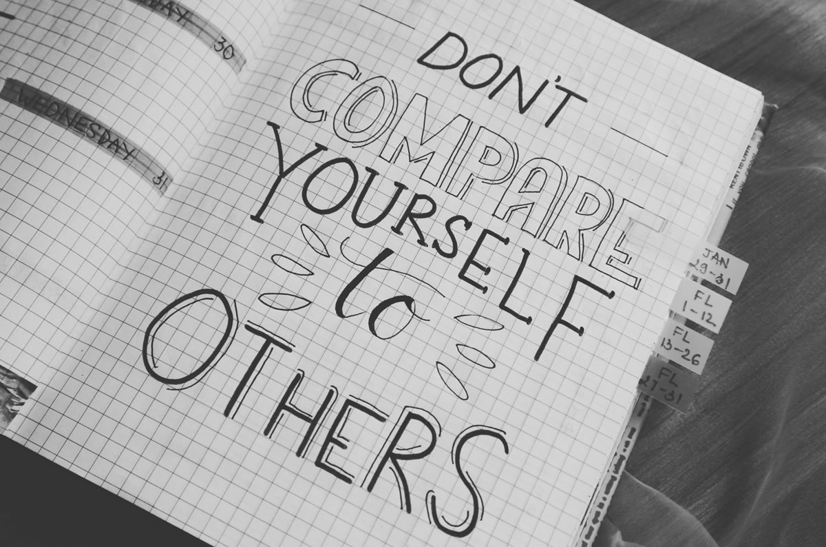 a notebook that has written "don't compare yourself to others"