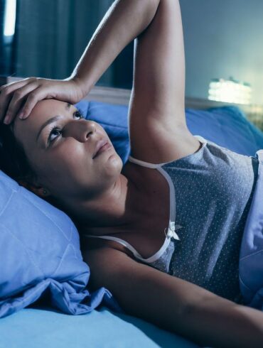 A woman lying awake at night with anxiety.