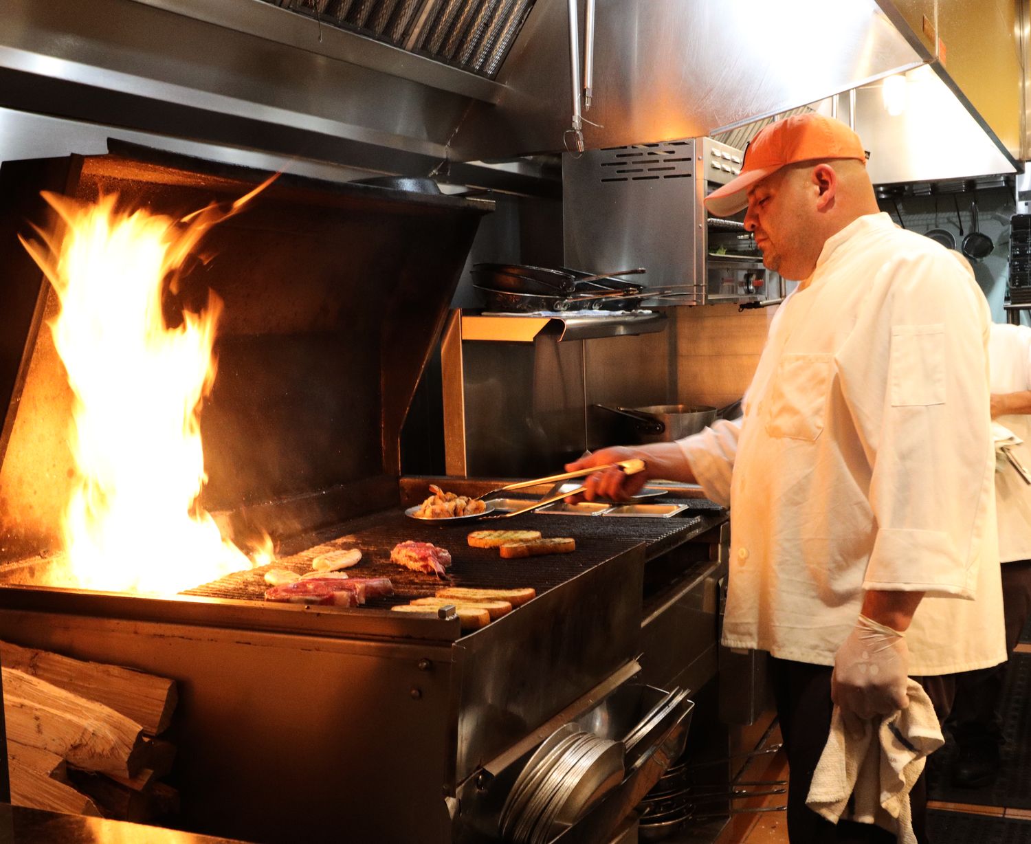 The chef at Matt's Red Rooster Grill in Flemington prepares meats on the open wood fired grill.
