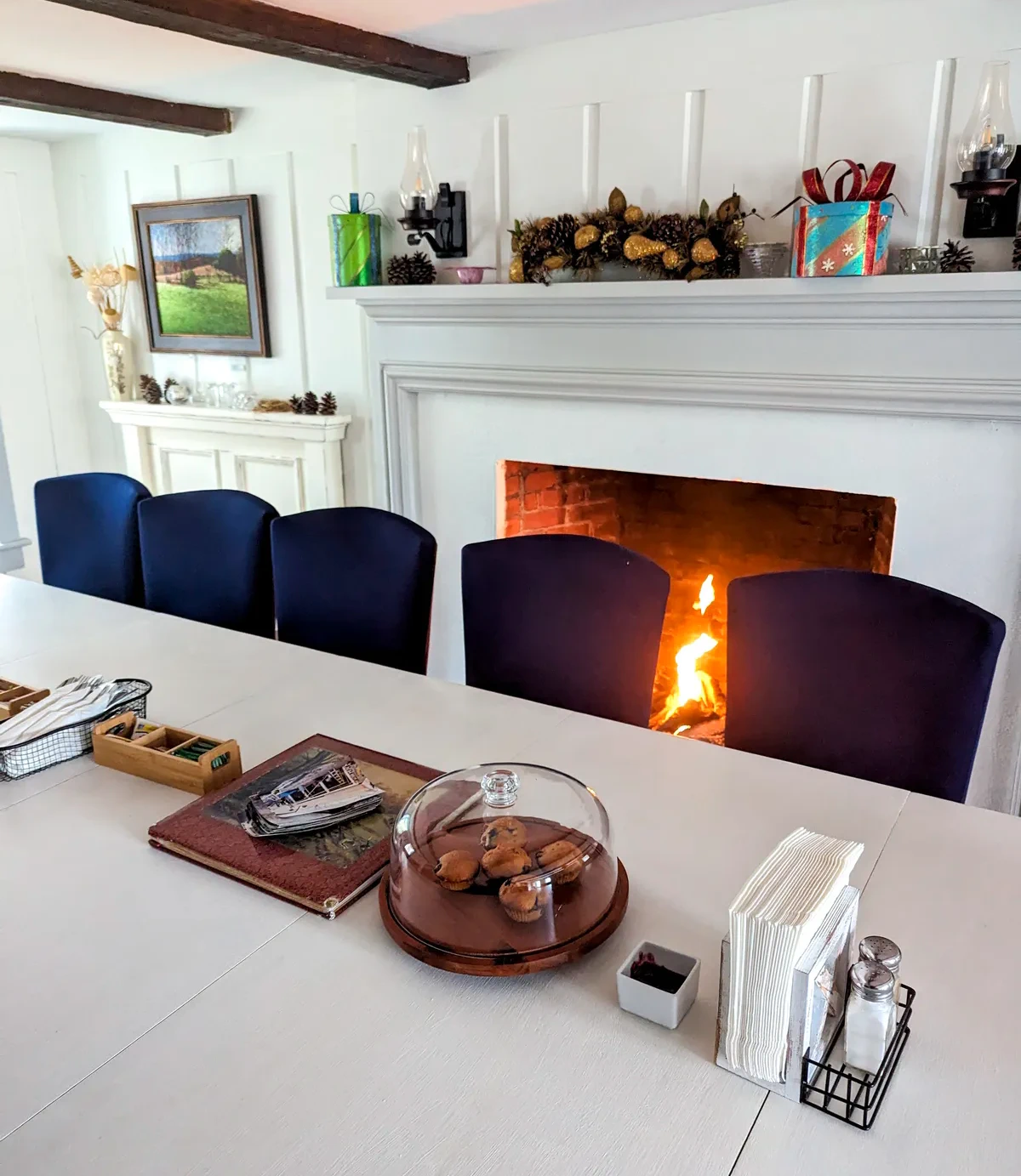 The breakfast dining area at Chimney Hill Estate Inn has a communal table and a roaring fireplace 