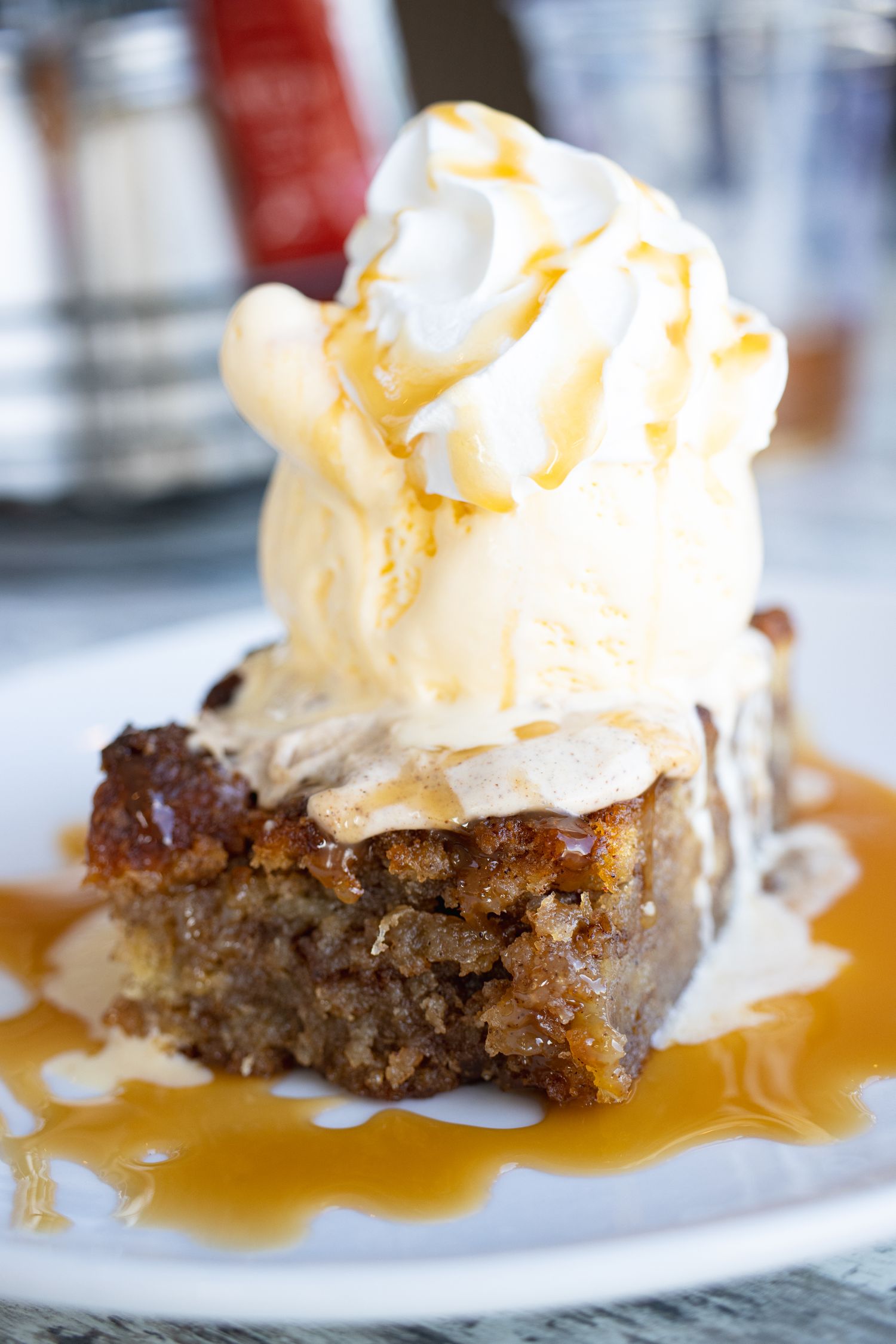 Cinnamon Bread Pudding with a heaping pile of ice cream and whipped cream.