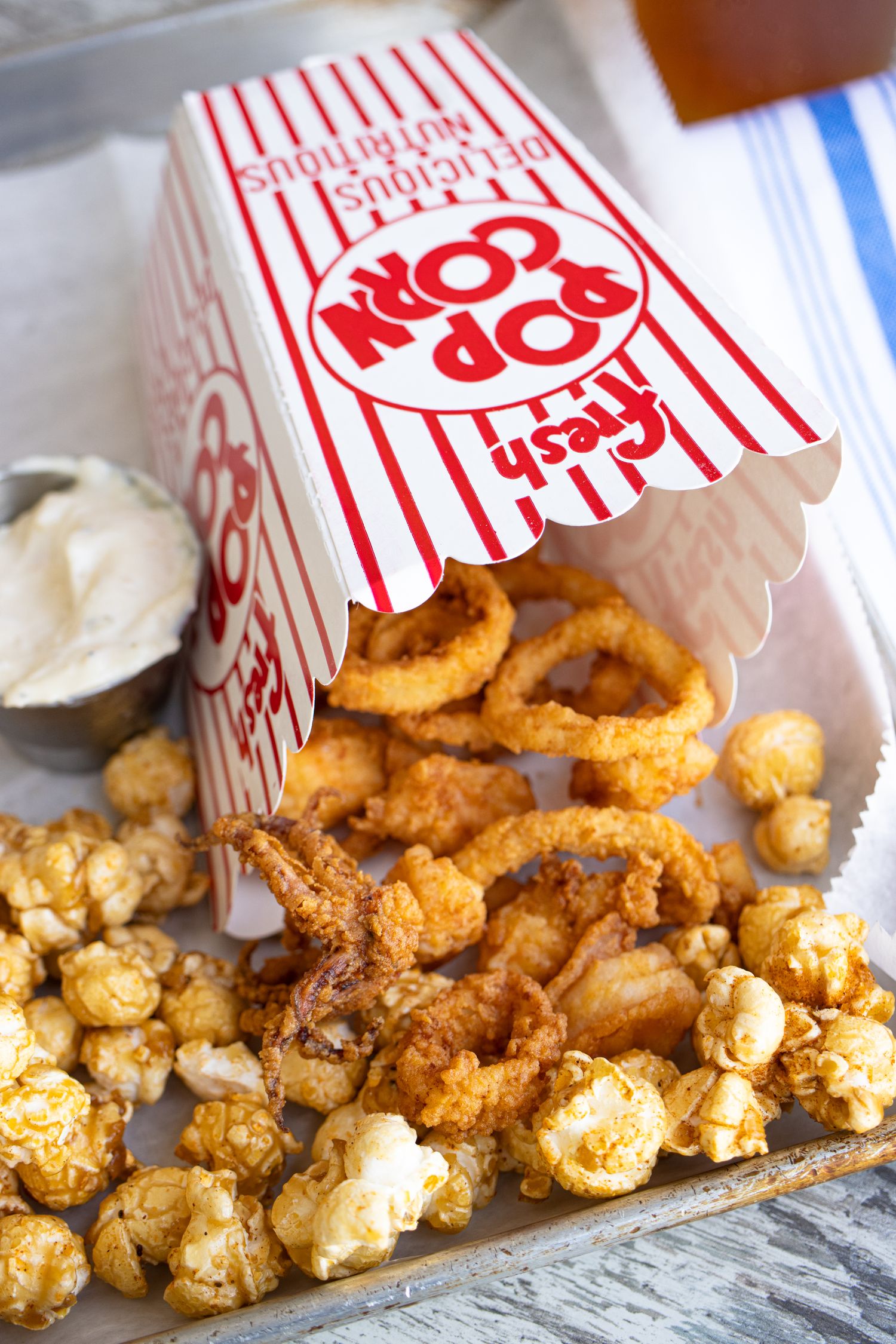 Dock House Popcorn. Crispy fried shrimp, rockfish, calamari and caramel popcorn are served in a cinema style popcorn bucket.
