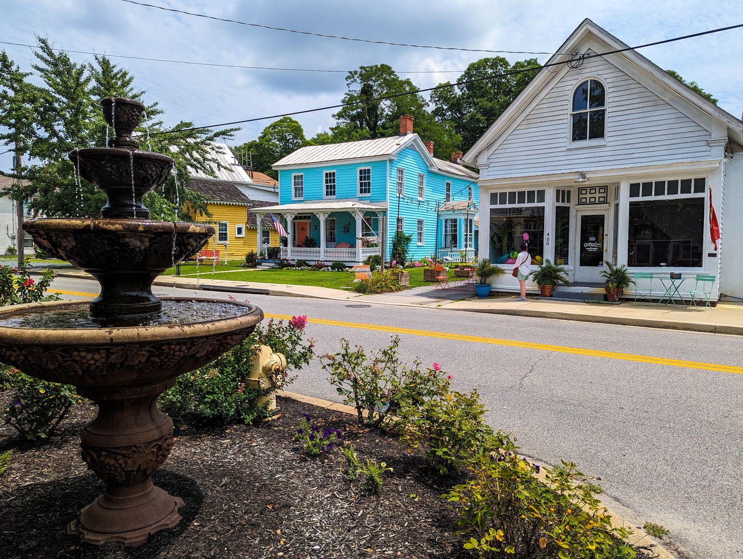 Strolling through Historic Stevensville, MD. Shops and a fountain line the street.