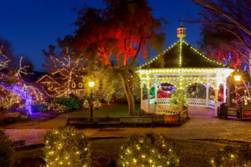 The gazebo at Peddler's Village lit up with Christmas lights at sunset.