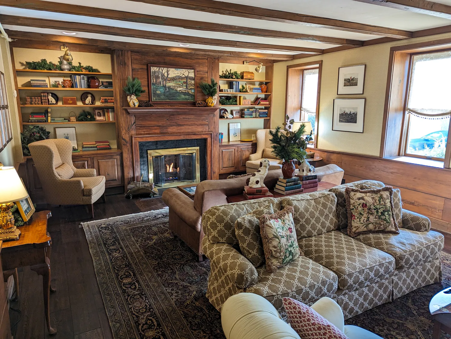 The lobby sitting area at Golden Plough Inn. 2 cozy couches, several chairs, and a roaring fireplace.