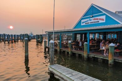the waterfront deck at fishermans crab deck. the sun sets in the distance.