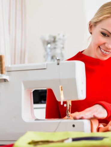 a woman crafting with upholstery fabric on a sewing machine