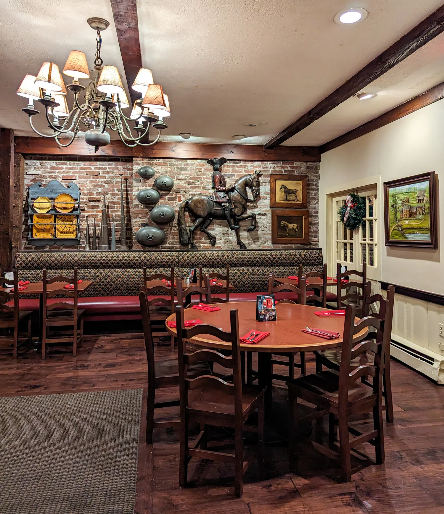 The newly renovated dining room at Cock 'N Bull Restaurant. Booths and a table with decor on the walls. 