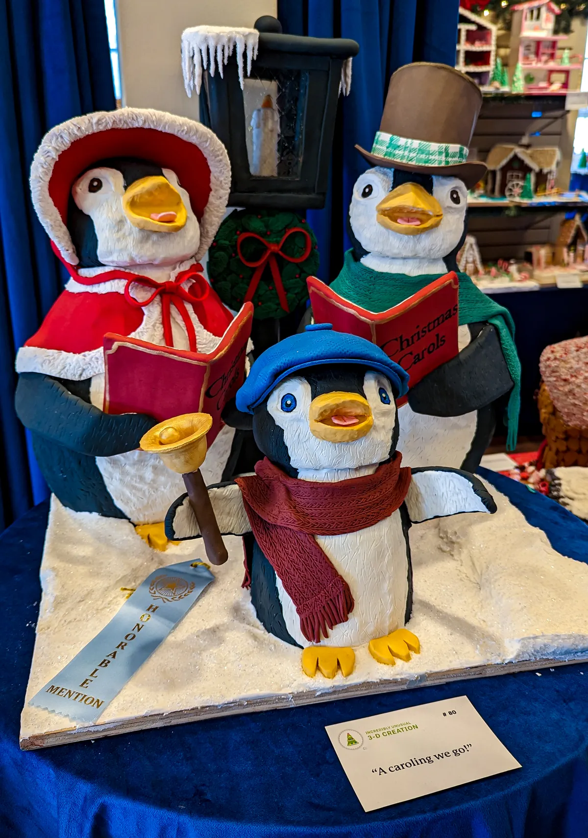 3 anthropomorphic ginger bread penguins are singing Christmas carols. 