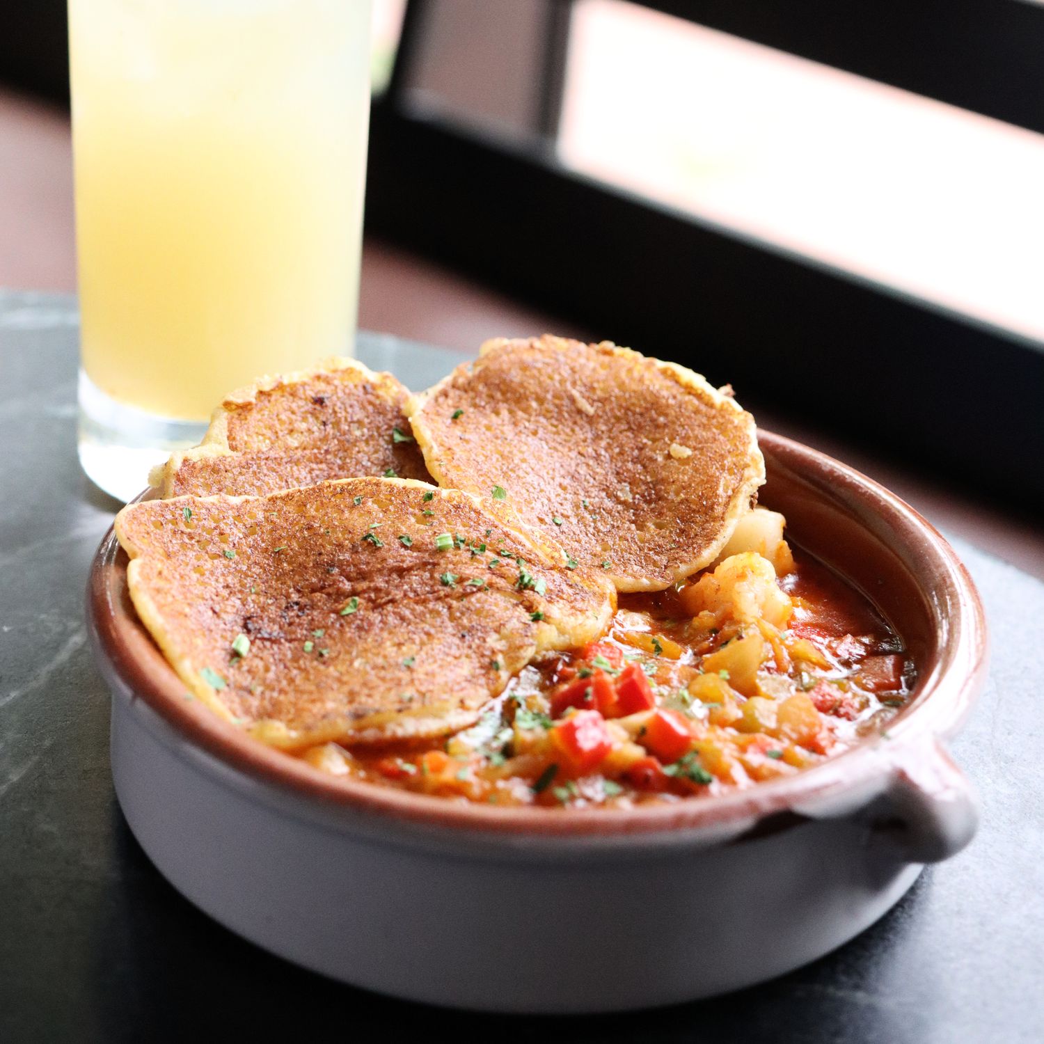 Johnny Cakes & Shrimp Creole at Cock 'N Bull Restaurant. Served in a bowl with Johnny Cakes on top. 